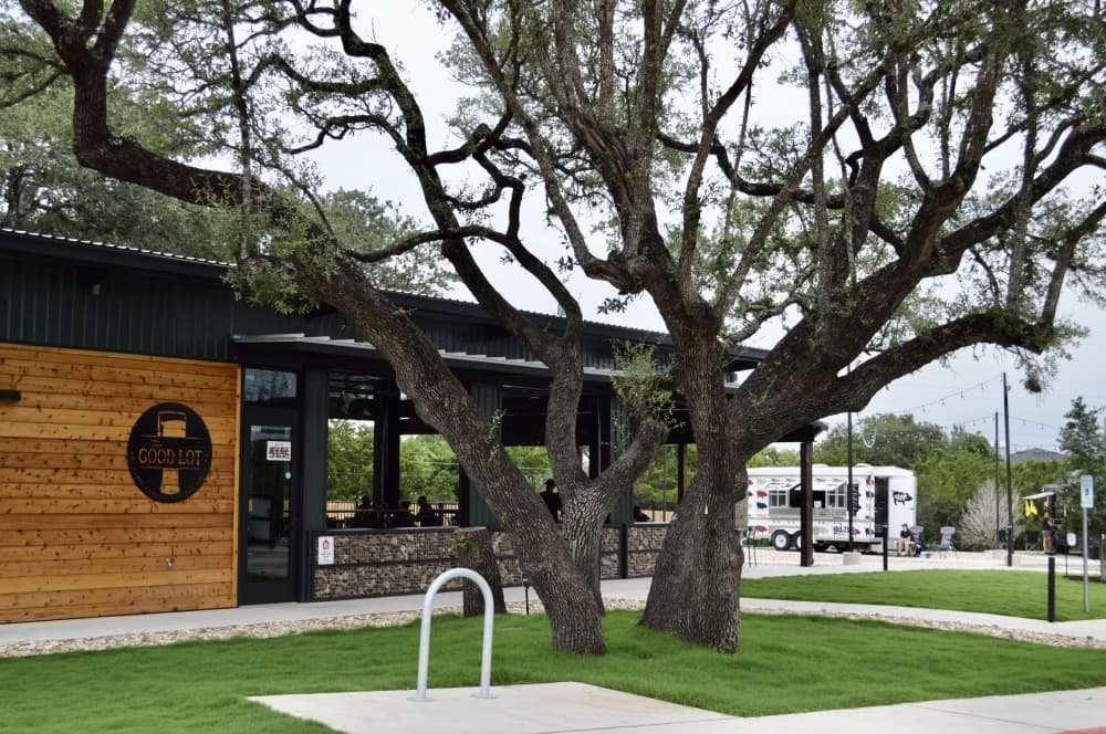 The Good Lot - Modern outdoor dining space with beautiful oak trees